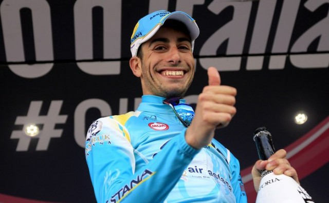 Italian cyclist Fabio Aru celebrates his victory on the podium of the 15th stage of the 97th Giro d'Italia (Tour of Italy) cycling race, from Valdengo to Plan di Montecampione, on May 25, 2014. AFP PHOTO/LUK BENIES        (Photo credit should read LUK BENIES/AFP/Getty Images)
