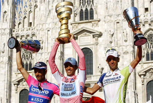 Pink jersey and overall leader Alberto Contador of Spain (C) holds the trophy on podium with compatriots, second placed Michele Scarponi (L) and third placed Vincenzo Nibali, after the 26km (16 miles) time trial in the 21st and last stage of the Giro d'Italia cycling race in Milan, May 29, 2011. Cervelo's rider David Millar of Britain won the stage while Contador won the 94th edition of the Giro d'Italia. REUTERS/Alessandro Garofalo ( ITALY - Tags: SPORT CYCLING IMAGES OF THE DAY)