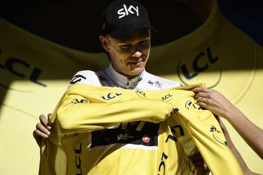 Great Britain's Christopher Froome puts his overall leader yellow jersey on the podium at the end of the 181,5 km fourteenth stage of the 104th edition of the Tour de France cycling race on July 15, 2017 between Blagnac and Rodez. / AFP PHOTO / Jeff PACHOUD